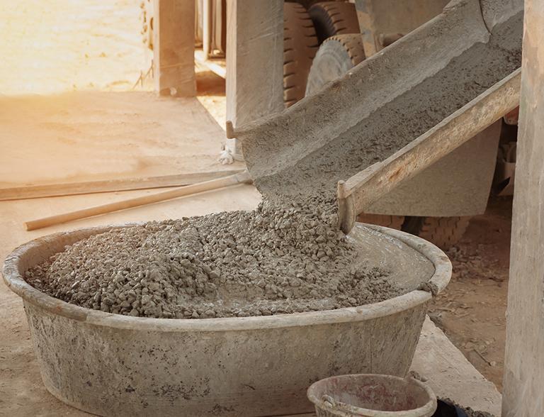 Beton zlewany z betoniarki do pojemnika